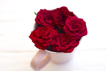 Arrangement from a cup for tea with roses