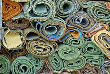 Disposed rolls of carpet padding.