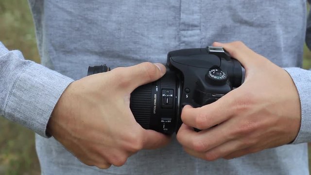 photo SLR camera in the hands of the photographer closeup