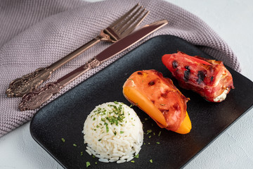 Gefüllte Paprika mit Reis auf schwarzem Teller