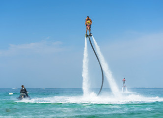 Father and his daughter posing at new flyboard at Caribbean tropical beach. Positive human...