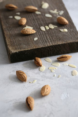 Fototapeta na wymiar Unrefined and peeled almond on a wooden desk