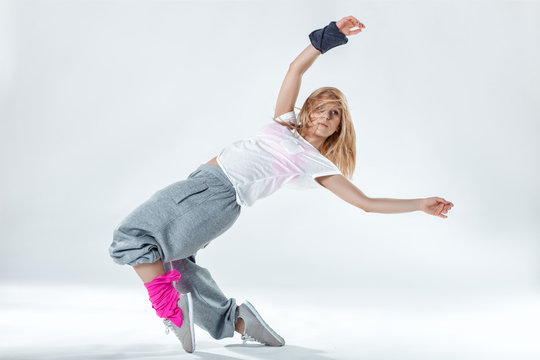 Young beautiful slim girl dancing on a white studio background