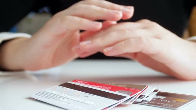 SLow motion video of young businesswoman throwing big stack of bak credit cards on desk in front of her