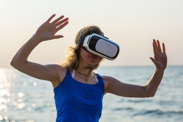 Young woman with virtual reality glasses at the sea background.