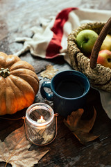Fototapeta na wymiar Autumn, a mug of tea and raindrops, fallen leaves, coziness, apples in a basket and pumpkin