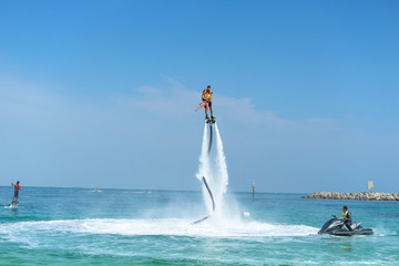 Father and his daughter posing at new flyboard at tropical beach. Positive human emotions, feelings, joy. Funny cute child making vacations and enjoying summer.