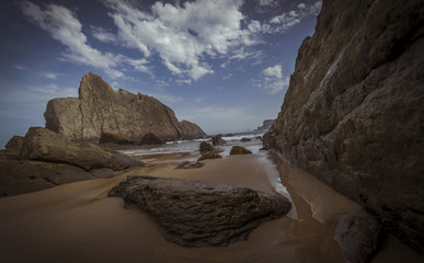 Travel, Beach with rocks in summer. Playa de la Arnía in Santander, Spain