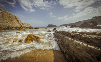 Ocean, Beach with rocks in summer. Playa de la Arnía in Santander, Spain