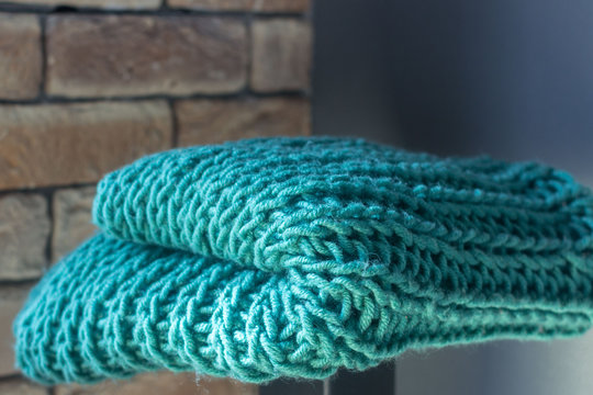 Knitting with knitting needles. A wool snod or scarf. A warm knitted thing in the wardrobe. Volumetric pattern of an elastic band. Winter accessory. Needlework in the form of knitting. 
