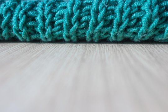 Knitting with knitting needles. A wool snod or scarf. A warm knitted thing in the wardrobe. Volumetric pattern of an elastic band. Winter accessory. Needlework in the form of knitting. 