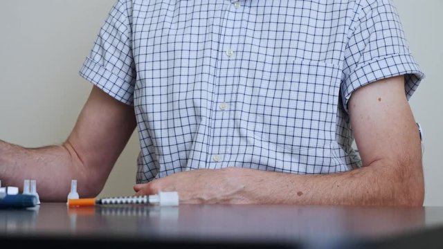 A man with diabetes brings the reading device to the sensor for measuring