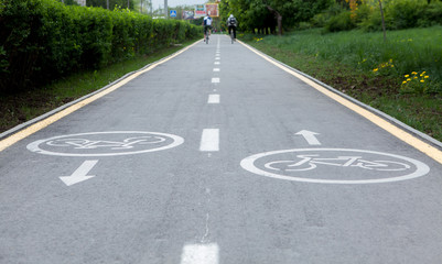 Obraz premium Painted signs on asphalt for bicycle dedicated lanes. A separate bike path in the city, cyclists on the cycle track