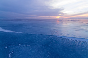 dark ice dawn on the frozen lake / a dull morning gave a soft dawn