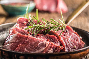 Close-up slices of beef tenterloin steak salt pepper and rosemary