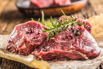 Close-up slices of beef tenterloin steak salt pepper and rosemary