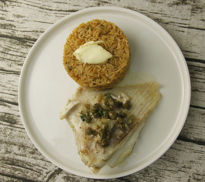 Ail de raie ravigote et riz aux agrumes sur une assiette