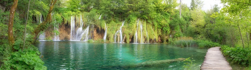 Fototapeten Das letzte Sonnenlicht erleuchtet den Reinwasser-Wasserfall im Nationalpark Plitvice. Farbiges Frühlingspanorama des grünen Waldes mit blauem See. Tolle Aussicht auf die Landschaft von Kroatien, Europa. © savantermedia