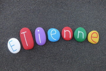 Etienne, french feminine given name with colored stones over black volcanic sand