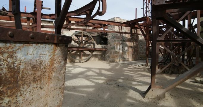 Second station of old Cable Car Chilecito-La Mejicana mine. Camera rotates and moves sideways showing wheels which made the system move, rails and detail of rusty wagon. National heritage