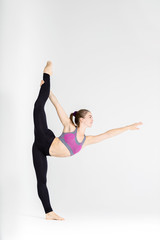 Fototapeta premium Young sportwoman stretching muscles on white background