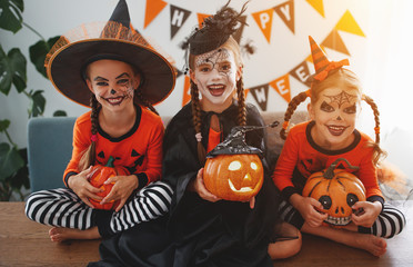 happy Halloween! a group of children in suits and with pumpkins in home