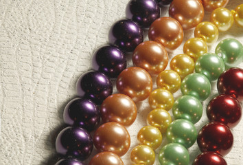 Multiple strands of colored pearls on a textured background