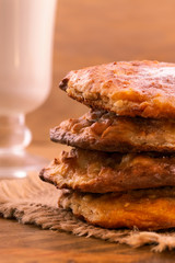Cookies with cottage cheese, baked in the oven until Golden brown, stacked in a column, vertical frame, wooden background.