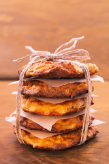 Cookies stacked in a stack with paper separation, tied with twine on a wooden background, a delicious gift.