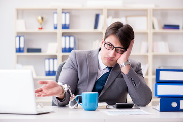 Businessman chained with handcuffs to his coffee
