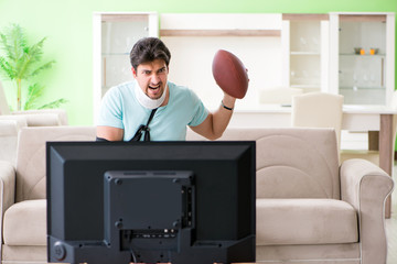 Man with neck and arm injury watching american football on tv