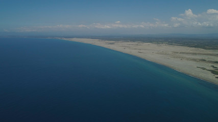 Aerial view of seashore with beaches, lagoons and coral reefs. Philippines, Luzon, Ilocos Norte. Coast ocean with turquoise water. Tropical landscape in Asia.
