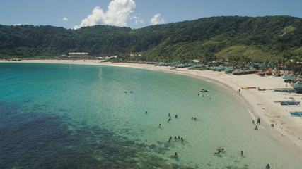 Aerial view of beautiful tropical beach with turquoise water in blue lagoon, Pagudpud, Philippines. Ocean coastline with sandy beach. Tropical landscape in Asia.