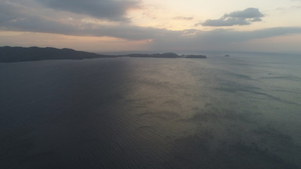 Fototapeta na wymiar Aerial view of coast of the island at sunset. Anilao, Caban Island, Philippines, Luzon. Travel concept.