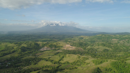Fototapeta na wymiar Aerial view of mountain valley with hillscovered forest, trees, mount Iriga. Luzon, Philippines. Slopes of mountains with evergreen vegetation. Mountainous tropical landscape.