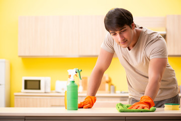 Obraz na płótnie Canvas Single man cleaning kitchen at home