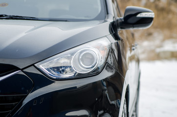 car in nature. Headlight of a black car