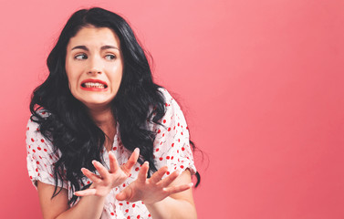 Disgusted face expression with young woman on a solid background