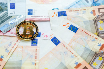 Golden Bitcoin Crypto currency coin on euro banknotes. Investments, cryptocurrency digital payment concept, new money or traditional concept