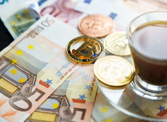coins Bitcoin - crypto currency and traditional money. The choice of the modern world. Investments, cryptocurrency digital payment concept, various of bronze and golden bitcoins and cup of coffee.   