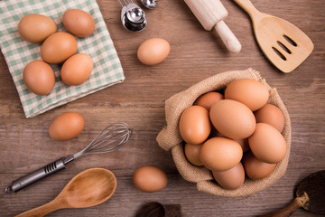 Fresh farm eggs on a wooden rustic background, Whipping eggs and whisk,top view with copy space