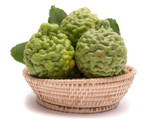 The kaffir lime leaves in the basket on a white background.