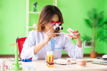 Woman dentist working on teeth implant