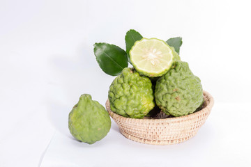 The kaffir lime leaves in the basket on a white background.