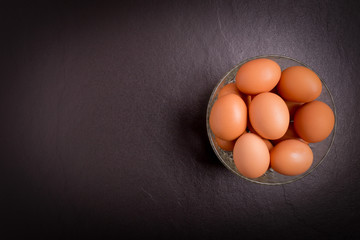 Fresh farm eggs on black stone background,top view with copy space