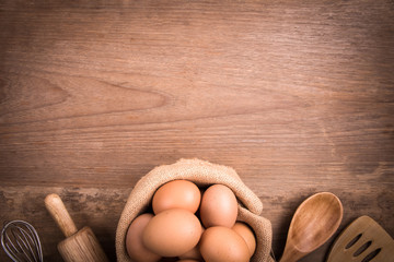 Fresh farm eggs on a wooden rustic background, Whipping eggs and whisk,top view with copy space