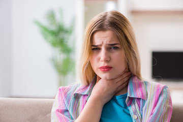 Young woman suffering from sore throat pain