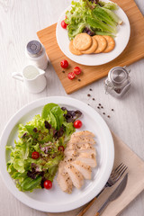 Vertical Grilled turkey salad on white dish on old wooden table.