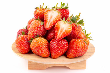 Heap of fresh strawberries in ceramic bowl  on the wooden tray.