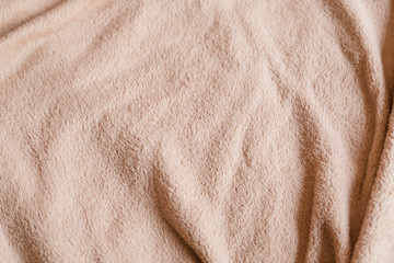 crumpled pink beige fleece blanket. comfy and warm cover. plush fabric texture background. copyspace concept.